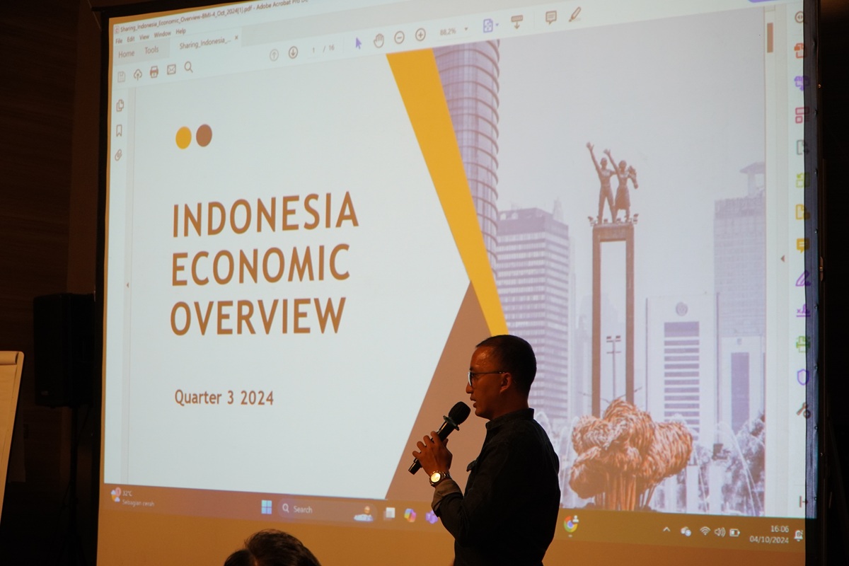 Narasumber menyampaikan materi ekonomi dengan presentasi di layar